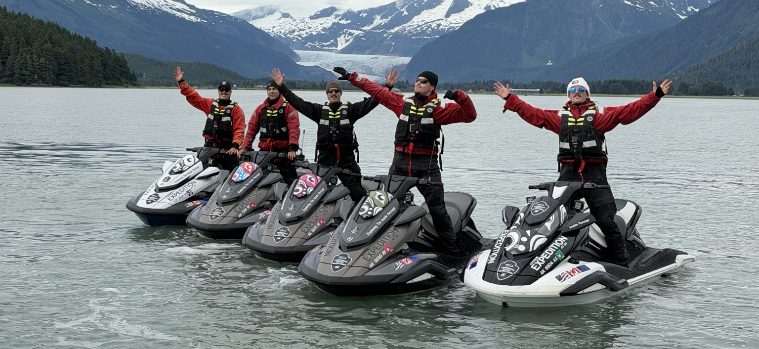 Jet ski group with glacier behind them